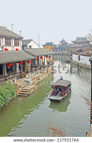 JINXI, SHANGHAI, CHINA  JANUARY 9: boat of tourists in a typical village water way.  The ancient village is a Shanghai tourist attraction with 100000 visitors per year. January 9, 2010, Jinxi, China