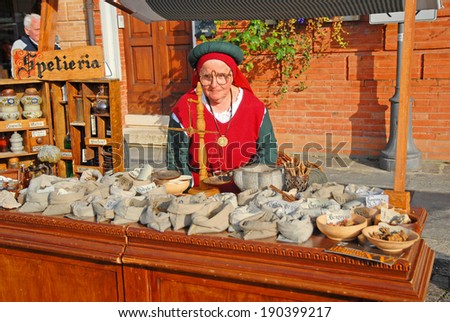 RUSSI, RAVENNA, ITALY- MARCH 30, 2014: lady attending a medieval seed shop at the Seven Sorrows annual fair. The exhibition is very popular in the city and attracts thousands of people.