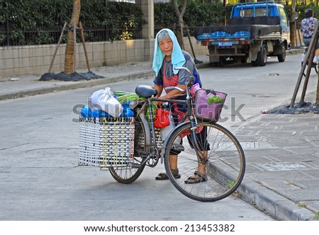 SHANGHAI, CHINA-AUGUST 12, 2013: lady running a vegetable shop. The largest Chinese city by population has thousand of these shops.