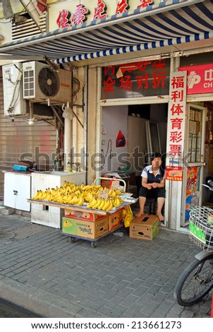 SHANGHAI, CHINA-AUGUST 24, 2013: lady running a banana shop. The largest Chinese city by population has thousand of these shops.