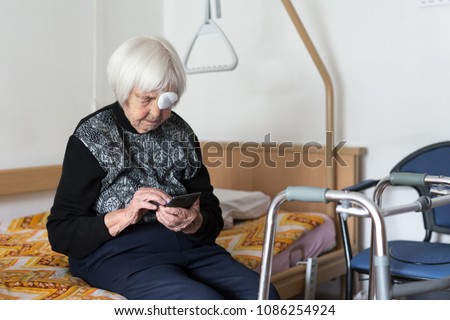 Image, Stock Photo Lonley elderly 95 years old woman sitting at the bad using modern mobile phone.