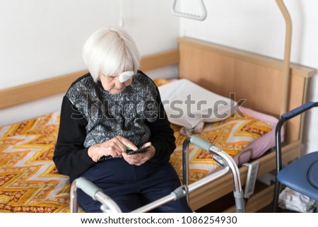 Similar – Image, Stock Photo Lonley elderly 95 years old woman sitting at the bad using modern mobile phone.