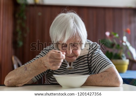 Similar – Foto Bild Einsame ältere Frau, die ihr Mittagessen im Altersheim verzehrt.