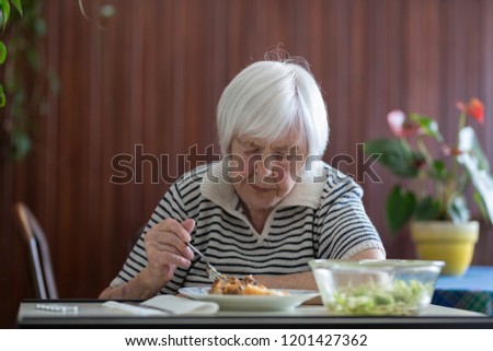 Similar – Foto Bild Einsame ältere Frau, die ihr Mittagessen im Altersheim verzehrt.