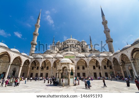 ISTANBUL - MAY 7: Tourists and prayers mixing at courtyard of Blue mosque on May 7, 2013; While still used as a mosque, the Sultan Ahmed Mosque has also become a popular tourist attraction.