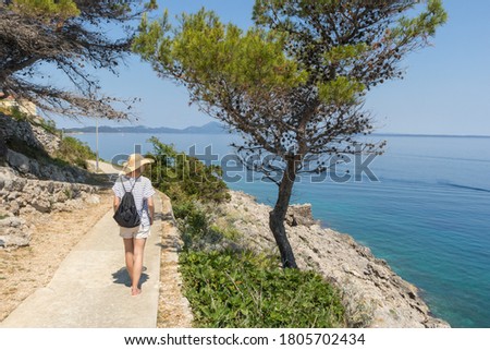 Similar – Image, Stock Photo Young active feamle tourist wearing small backpack walking on coastal path among pine trees looking for remote cove to swim alone in peace on seaside in Croatia. Travel and adventure concept.