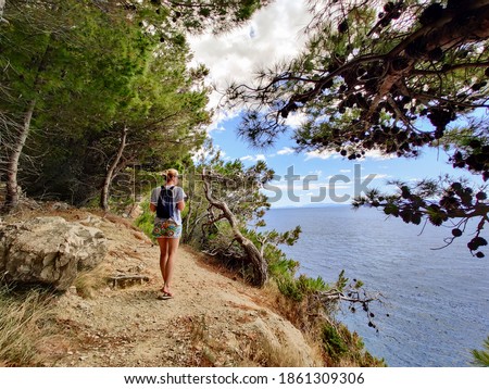 Similar – Image, Stock Photo Young active feamle tourist wearing small backpack walking on coastal path among pine trees looking for remote cove to swim alone in peace on seaside in Croatia. Travel and adventure concept.