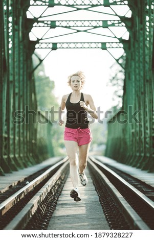 Similar – Image, Stock Photo Athlete running on railaway bridge training for marathon and fitness. Healthy sporty caucasian woman exercising in urban environment before going to work. Active urban lifestyle