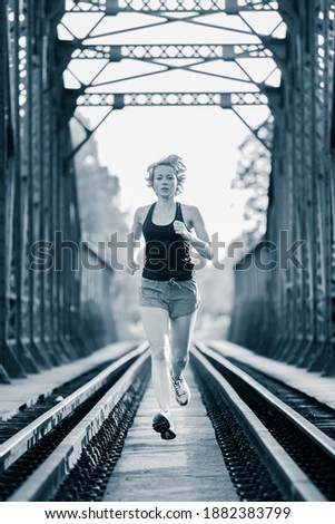 Similar – Image, Stock Photo Athlete running on railaway bridge training for marathon and fitness. Healthy sporty caucasian woman exercising in urban environment before going to work. Active urban lifestyle