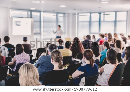 Business and entrepreneurship symposium. Speaker giving a talk at business meeting. Audience in conference hall. Rear view of unrecognized participant in audience. Photo stock © 
