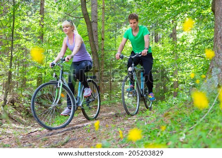 Young spoty active cople biking in nature. Active lifestyle. Activities and recreation outdoors.