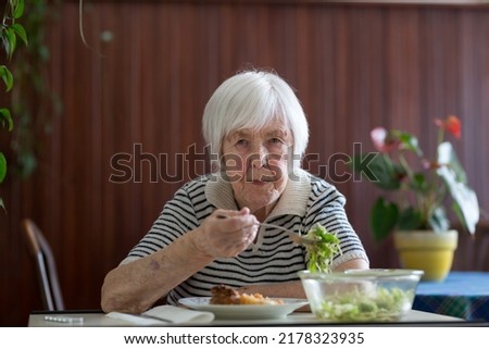 Foto Bild Einsame ältere Frau, die ihr Mittagessen im Altersheim verzehrt.