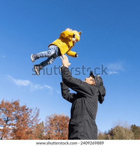 Foto Bild Junger Vater wirft sein Baby Tochter hoch in den Himmel im Park im Sommer Tag. Vatertag