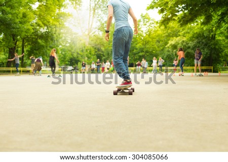 Girl wearing black boots and stockings practicing long board riding in skateboarding park. Active urban life. Urban subculture. Copy space.