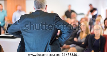 Business man leading a business workshop. Corporate executive delivering a presentation to his colleagues during meeting or in-house business training. Business and entrepreneurship concept.