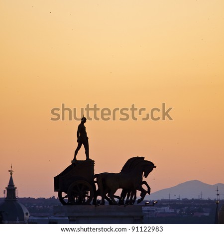 Ancient statue of a roman soldier standing on the coach on the roof of one of the buildings seen from C?rculo de Bellas Artes in Madrid, Spain. Foto stock © 