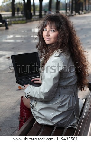 A beautiful brunette model working on a computer.