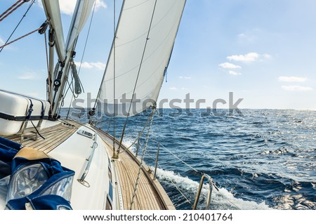 Sailing boat deck with hoisted sails and teak deck