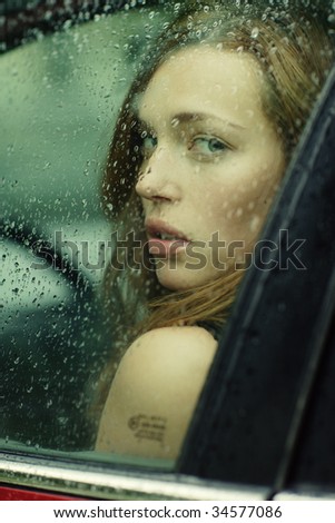 portrait of a young woman in the car during the rain