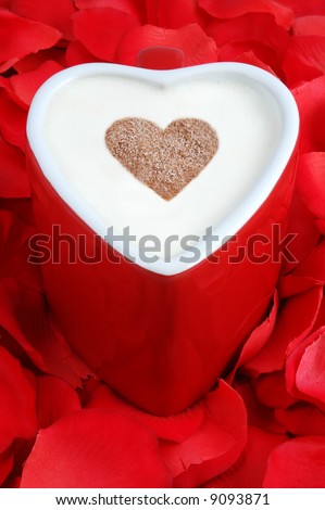 heart shaped coffee cup with chocolate heart on a bed of rose petals