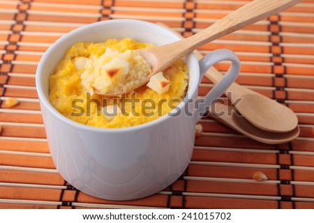 Polenta baked with chunks of cheese in a ceramic cups