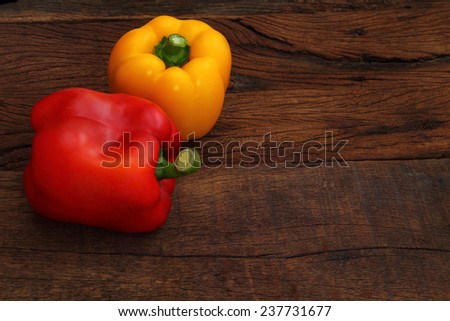 Red and Yellow sweet pepper on wood.