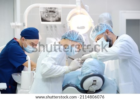 Surgeon and nurse during a dental operation.Anesthetized patient in the operating room.Installation of dental implants or tooth extraction in the clinic. General anesthesia during orthodontic surgery. Сток-фото © 
