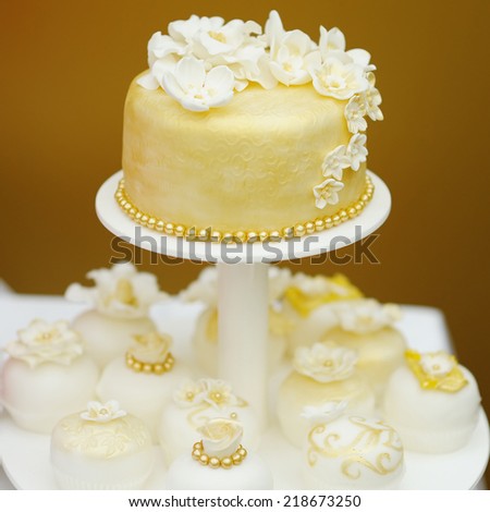 Delicious lemon wedding cake and cupcakes decorated with flowers