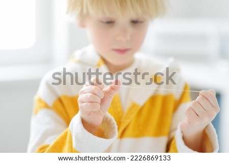 Similar – Image, Stock Photo Child flossing face and tiring milk tooth to pull out