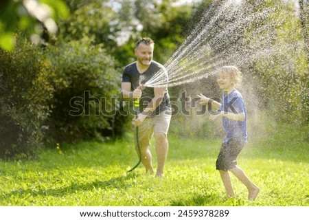Similar – Image, Stock Photo Watering the lawn with water in summer. gardening concept. drops of water from the ameliorative irrigation system are fed to grow ing garden plants against a sunny day