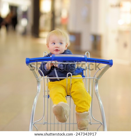 European toddler boy sitting in the shopping cart