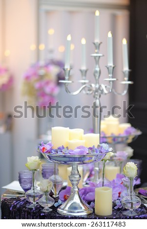 Part of stylish indoor wedding party or date interior with flowers and candles