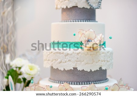 Delicious white and grey wedding or birthday cake decorated with flowers
