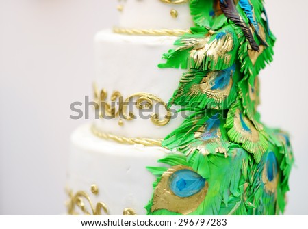 Delicious white wedding cake decorated with gold and green tracery