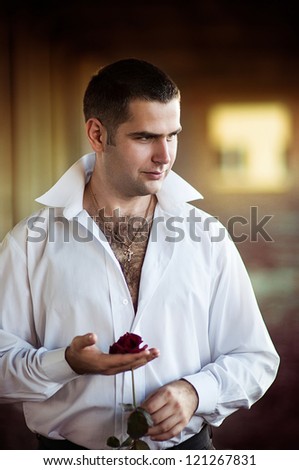 Portrait of a sexy man with a rose in hand