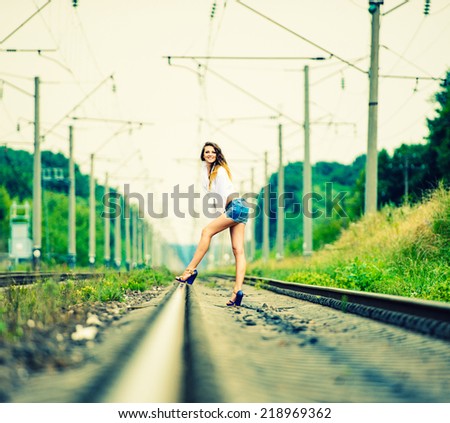 Portrait of sexy brunette woman in fashion style on railway track
