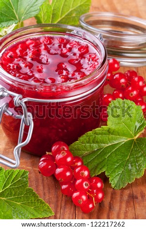 red currant jam with fresh berry on wood background