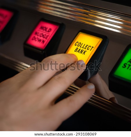 A hand pushes the Â?Â?collect bankÂ?Â? button on a slot machine.  This generally ensures that the gambler to walk away, thereby securing whatever wins or losses have been made.