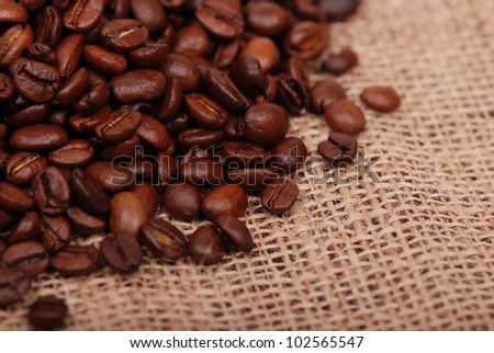 Studio image of dark brown coffee beans on the background of tissue/dark brown coffee