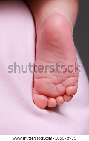 studio image of abstract Art photo Tiny foot of cute newborn over textured background/baby foot