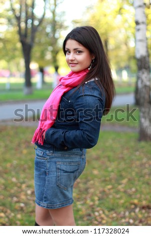 Image of beautiful young brunette woman spending time in the autumn park/Young woman outdoor at autumn time