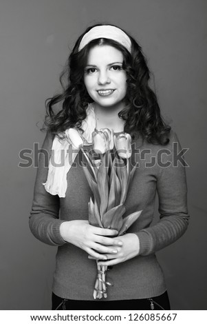 Female black and white portrait of young woman with tulips/Beautiful young girl with a bouquet of spring flowers
