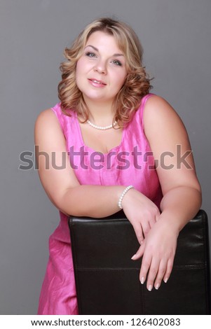 Smiley face of european charming woman wearing bright pink elegant dress