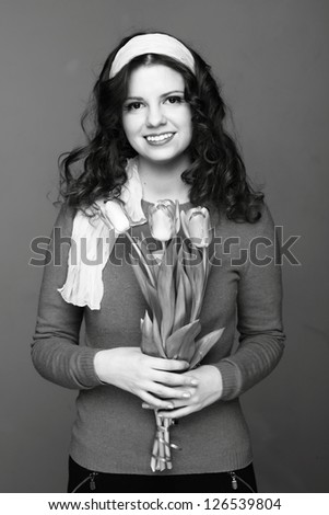 Studio black and white image of young girl with a bouquet of spring flowers