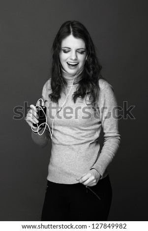 Studio portrait of beautiful european young woman enjoying modern music on Beauty and Fashion theme