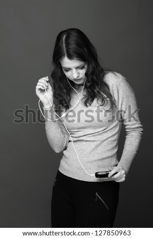 Black and white photo of a girl with emotional telephone listening to music and dancing