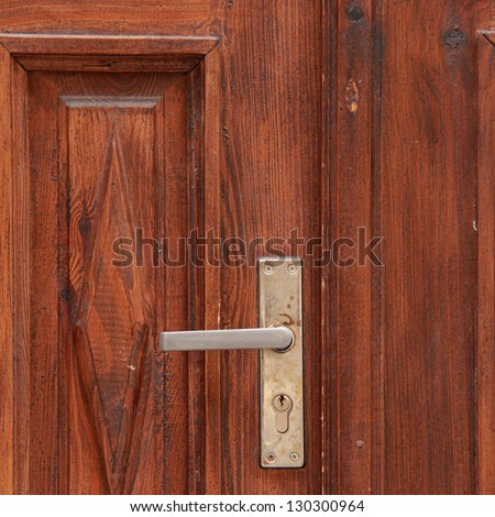 Background of a wooden door with light wood with a metal lock and handle