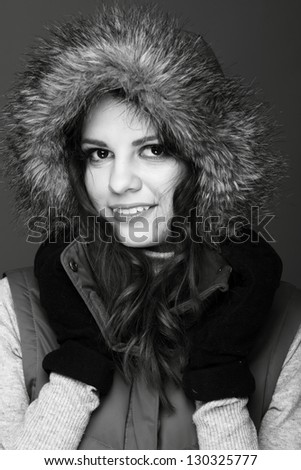 Black and white photo of a positive girl in warm clothes