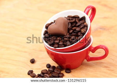 Red cup full of coffee beans and a candy cane from the top on wooden table on Food and Drink