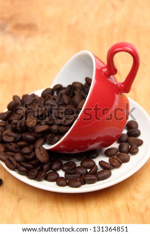 raw coffee beans in  red coffee cup with heart symbol on holiday theme